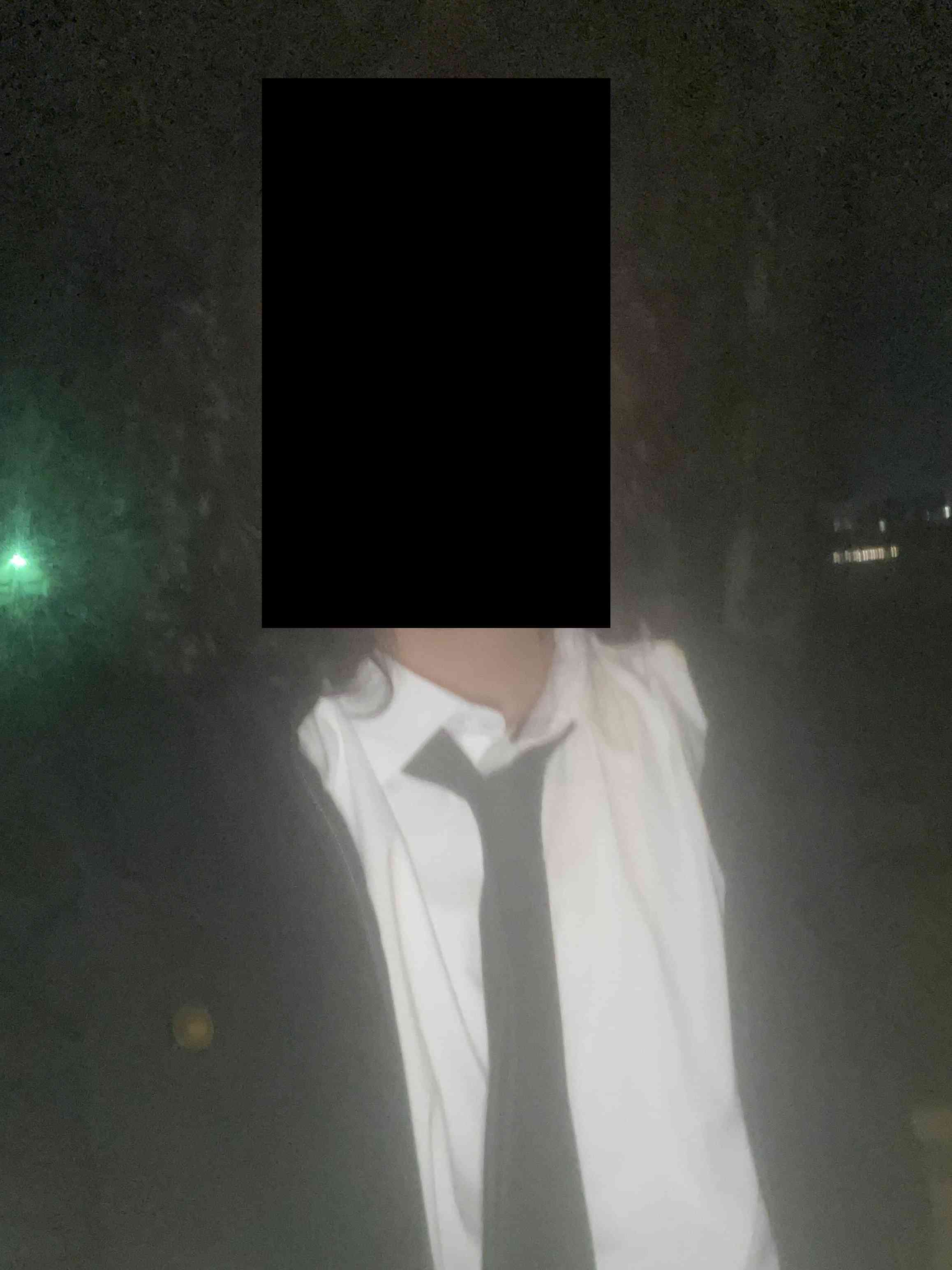 A person in a fancy suit with their face blurred out.